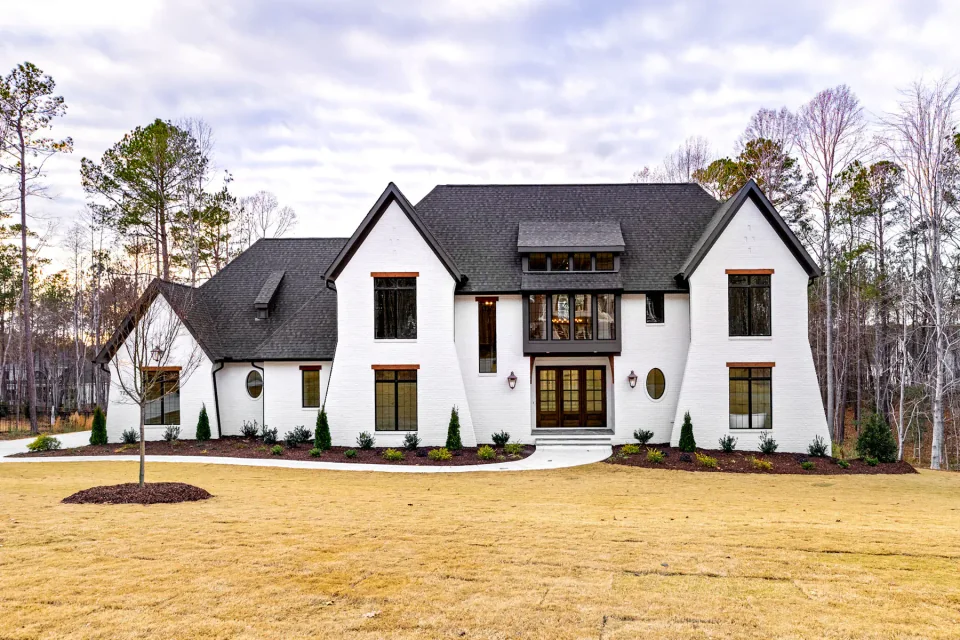 White gabled home with dark windows and a recessed front porch.