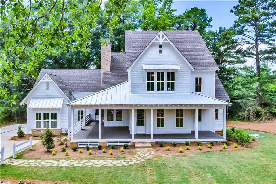 White home with a broad front porch and a stone base.