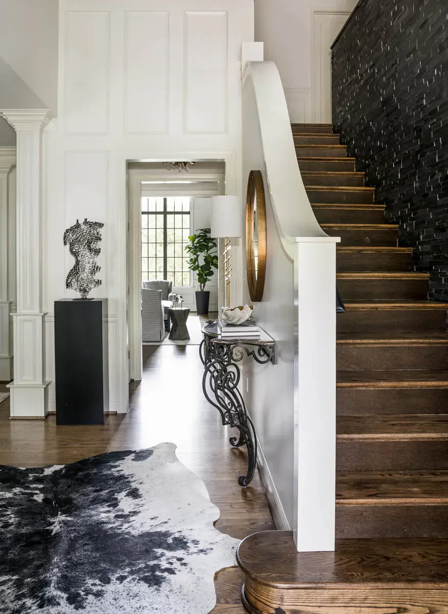 Entry hall with a curved stair, dark floor and a console beside the front door.