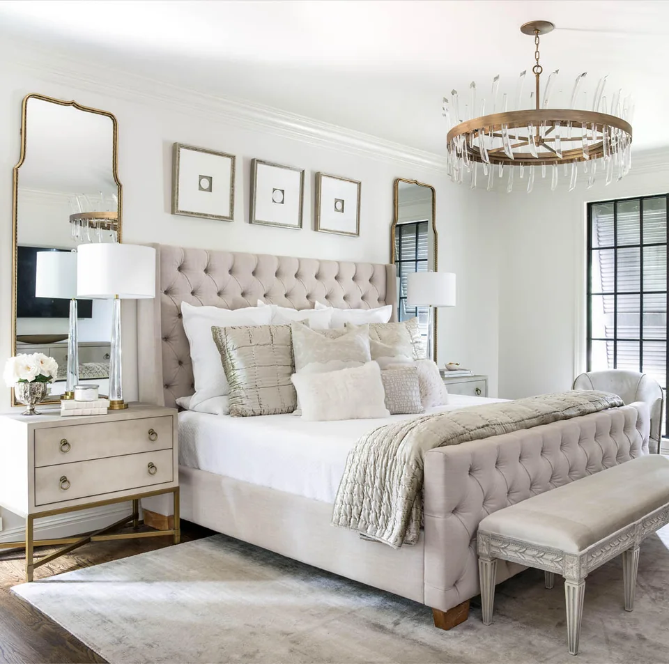Bedroom with a tufted headboard, pale bedding and windows on two walls.